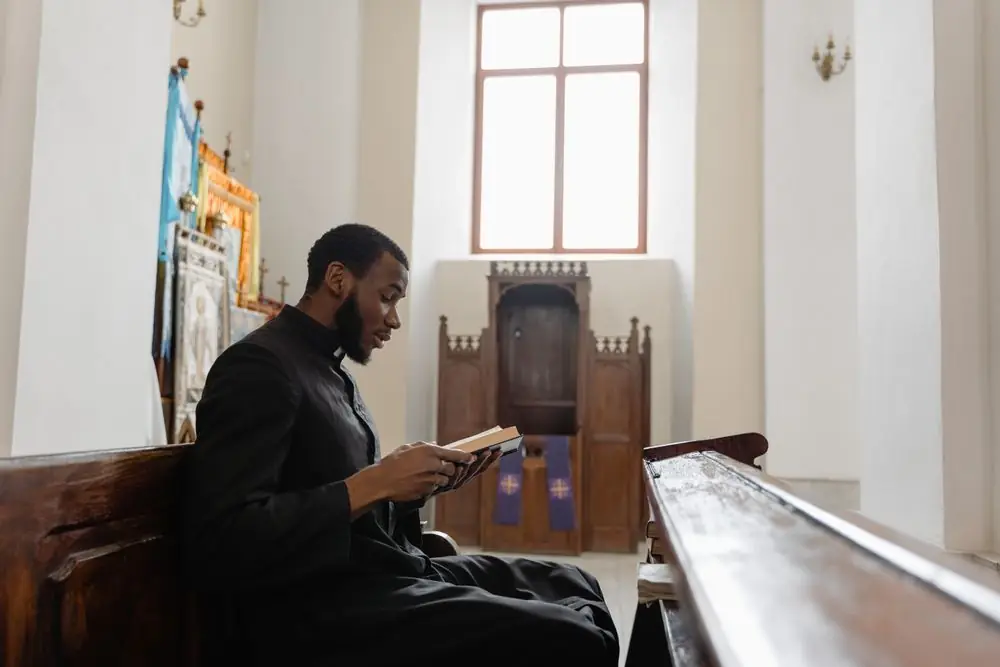 Homme afro-américain lisant la Bible dans une église