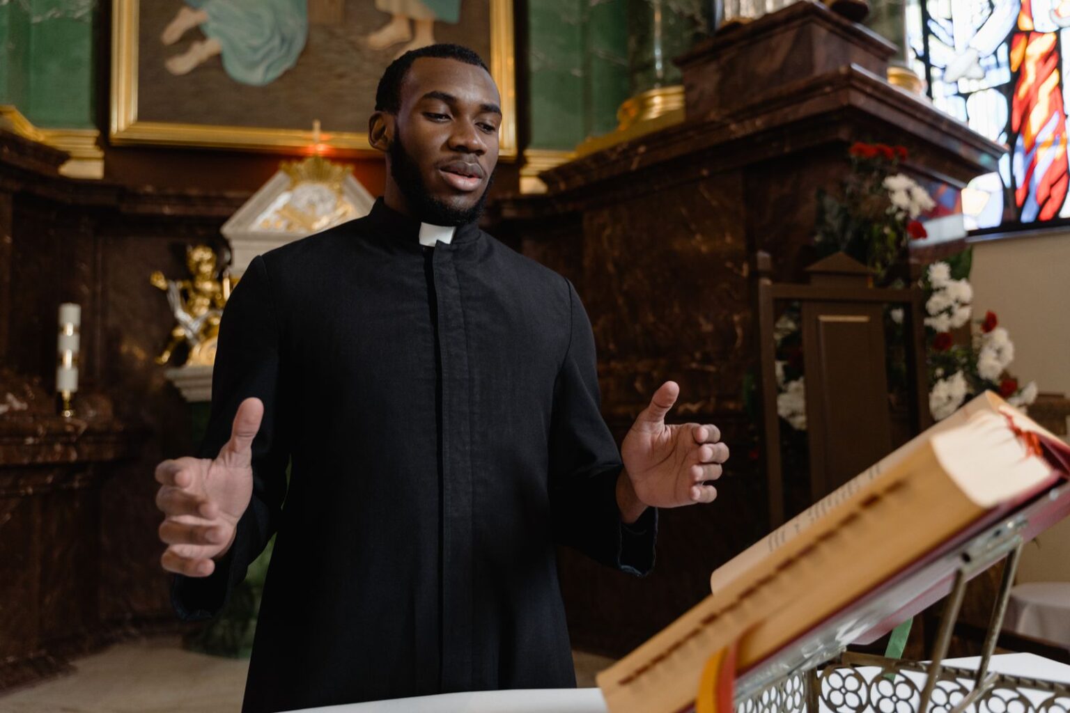 Pasteur noir prêchant avec une Bible ouverte dans une église
