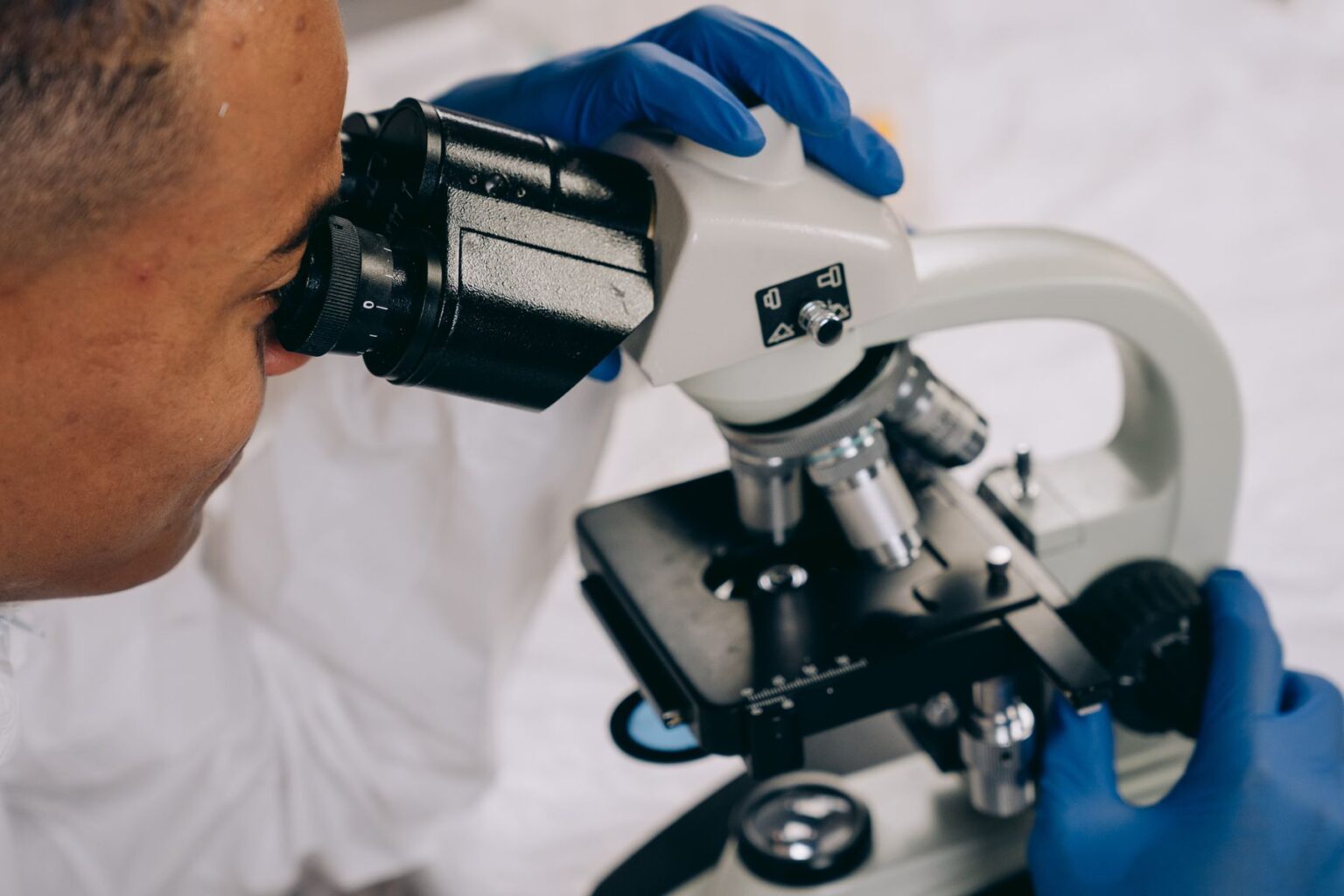 Scientifique noir examinant un échantillon au microscope dans un laboratoire moderne
