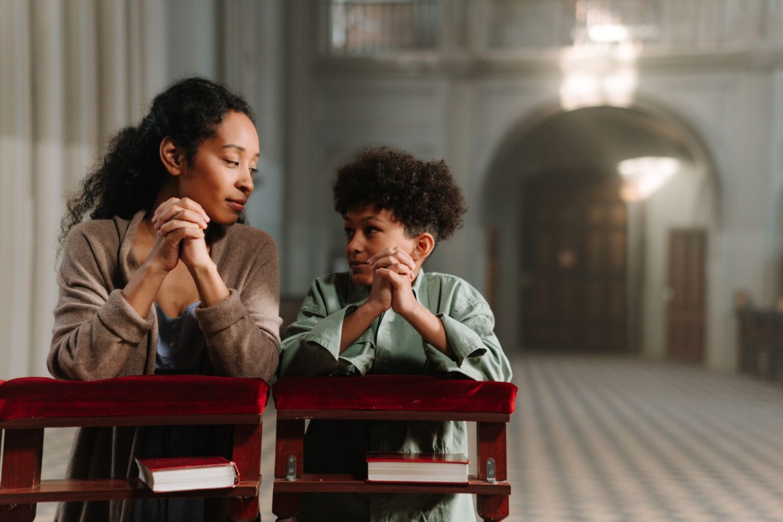 Mère et fils noirs priant ensemble dans une église